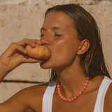 pige med perlehalskæde med pink perler, købt i HAUSFRAU butikkerne