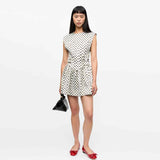 pige i hvid prikket kjole fra Ganni