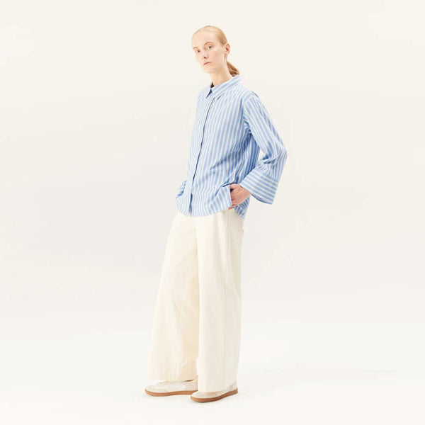 pige i stribet skjorte og hvide jeans